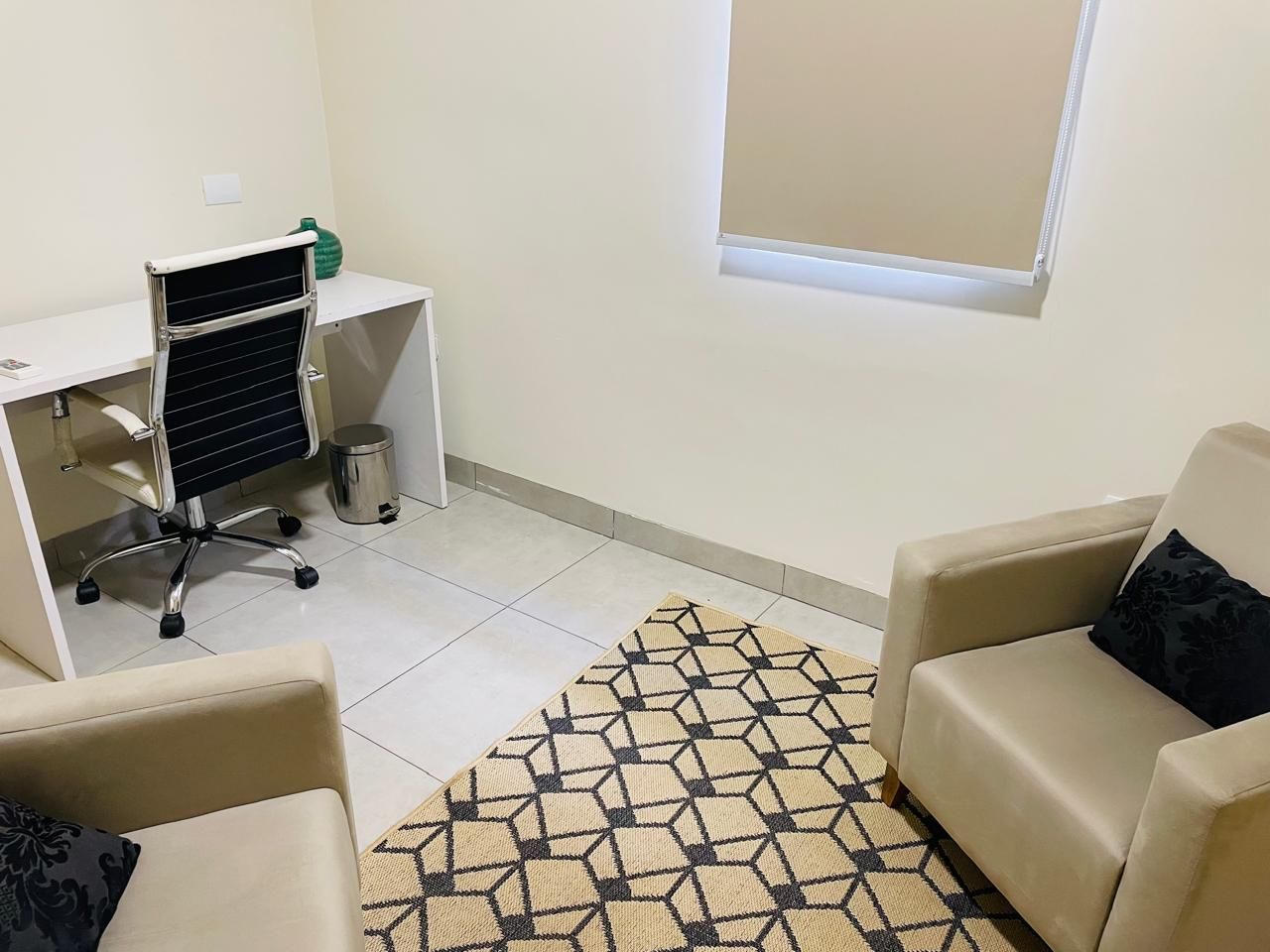 Sala com mesa branca e cadeira de escritório