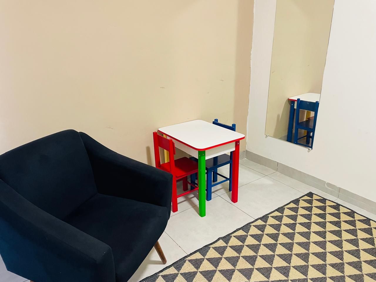 Sala com mesa infantil colorida e poltronas